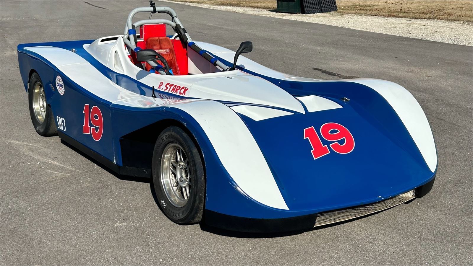 Blue and white Spec Racer Ford SRF3 number 19 on pavement