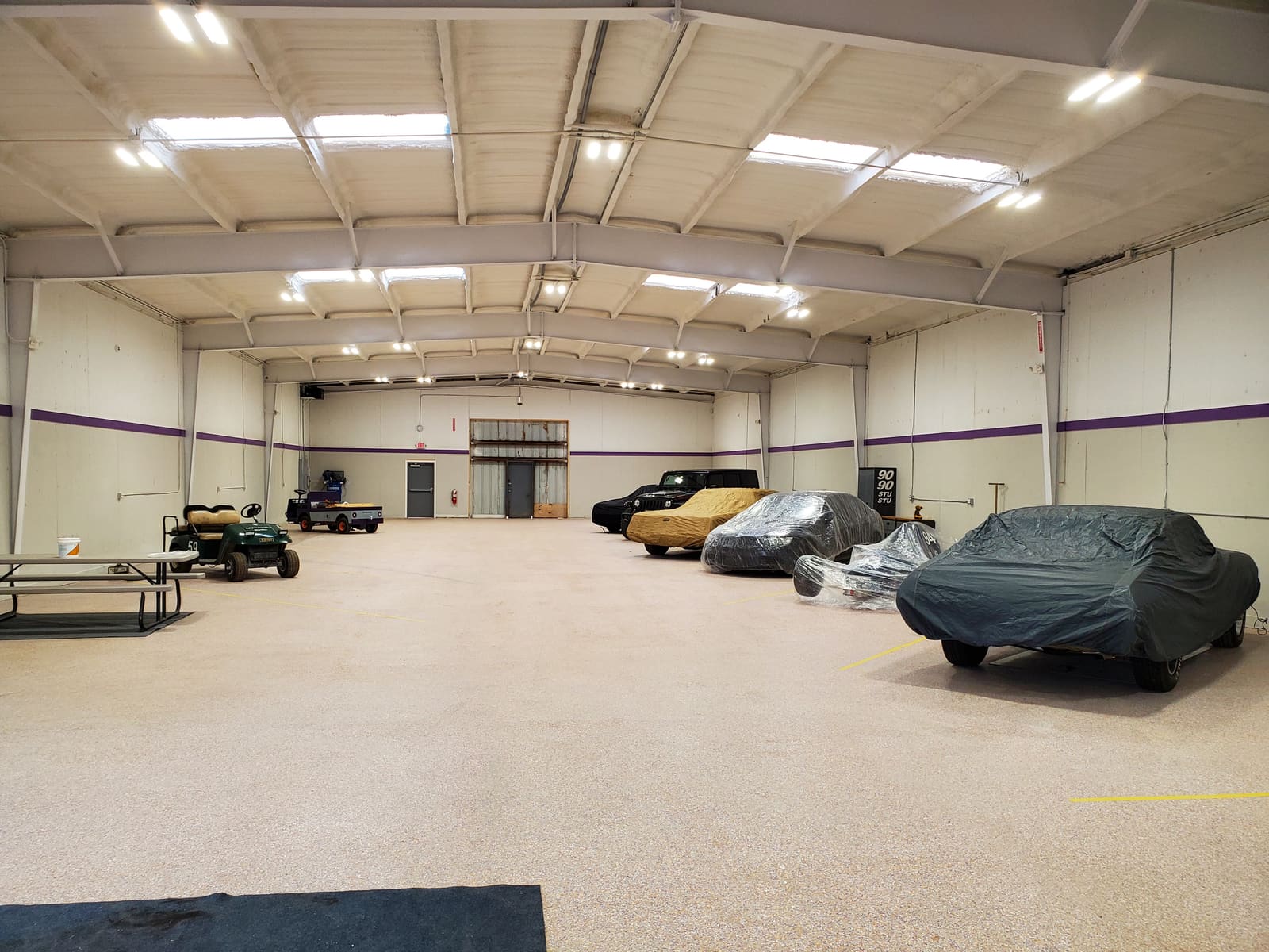 Covered customer cars and golf carts in the B2 Motorsports storage hall